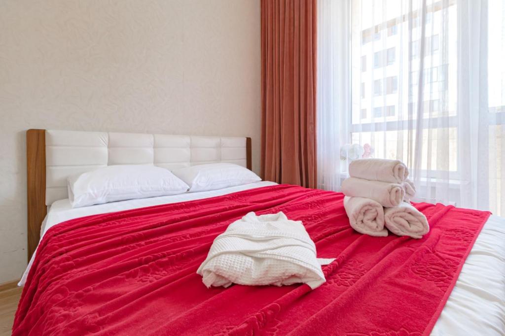 1 dormitorio con 1 cama con toallas en Expo Residentce Кабанбай Батыра 60А, 