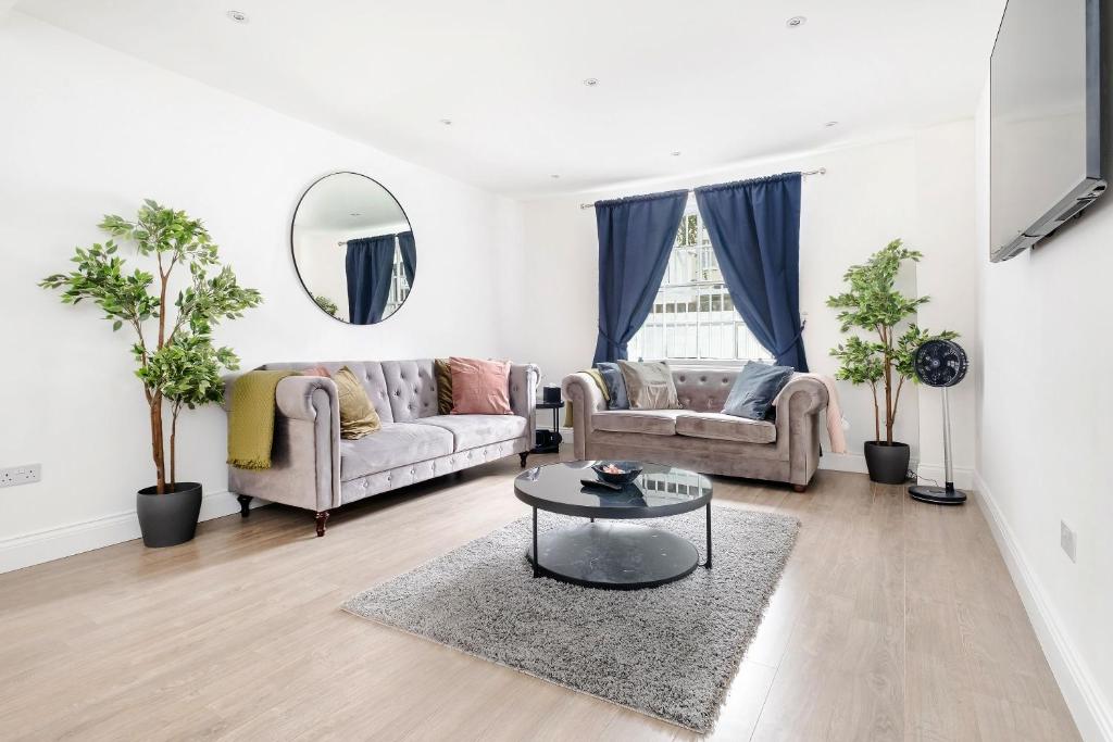 a living room with two couches and a table at Urban Luxury 4-Bed Retreat Explore And Relax in London