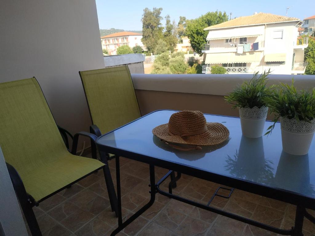 a straw hat sitting on a table on a balcony at Anna's Cozy Flat in Lefkada