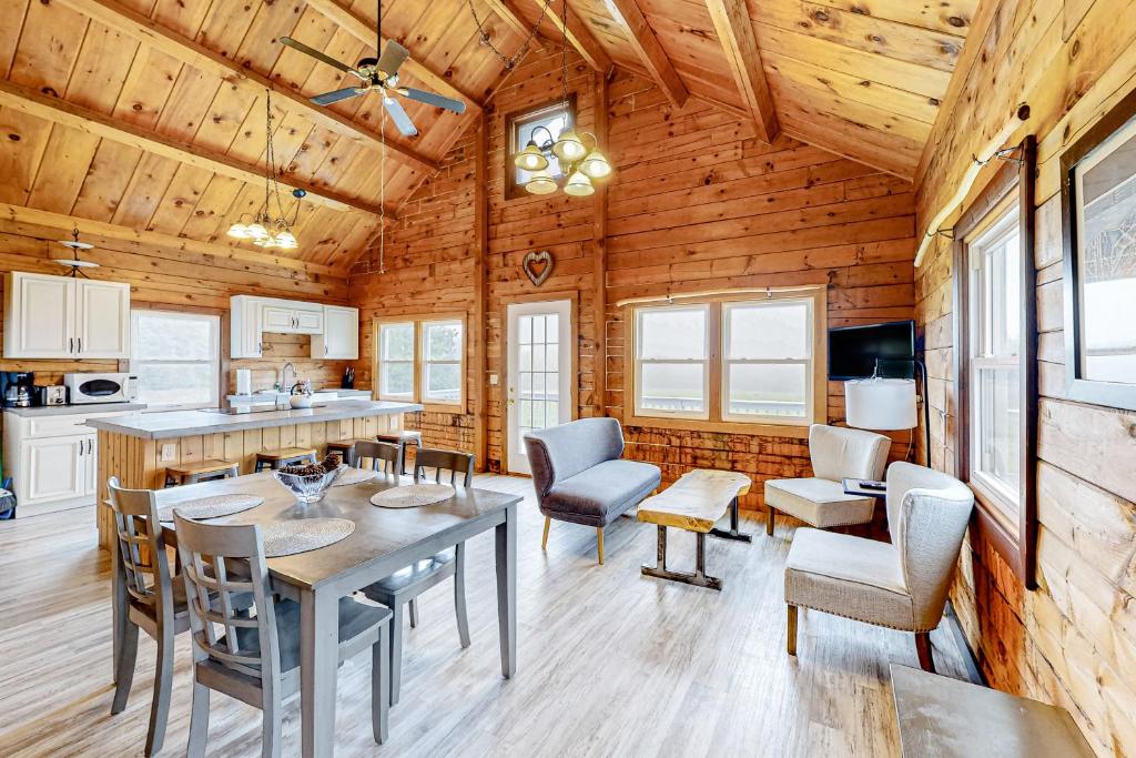 a kitchen and dining room with a table and chairs at Modern Log Chalet - Upper Level in Montgomery