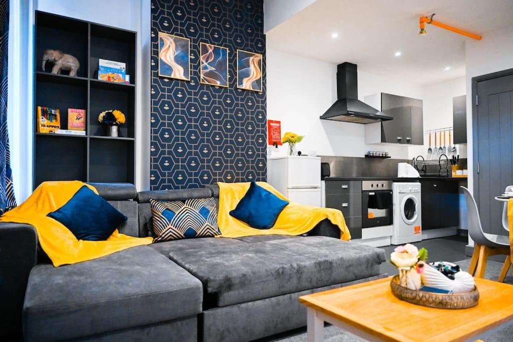 salon z szarą kanapą i kuchnią w obiekcie Apartment in city centre Leicester w mieście Leicester