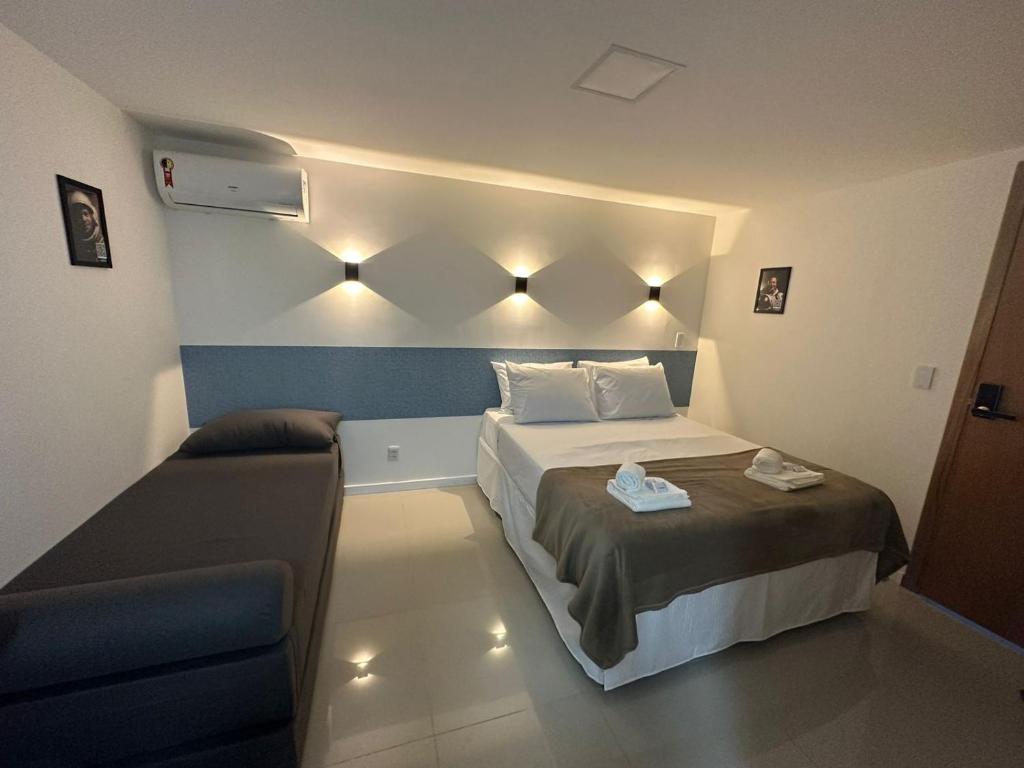 1 dormitorio pequeño con 1 cama y 1 sofá en Audaar Tech Suítes - Aeroporto de Congonhas en São Paulo