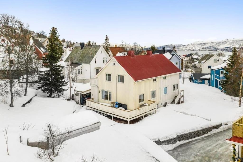 a house with a red roof in the snow at Cozy 130sqm house right above the city center. in Tromsø