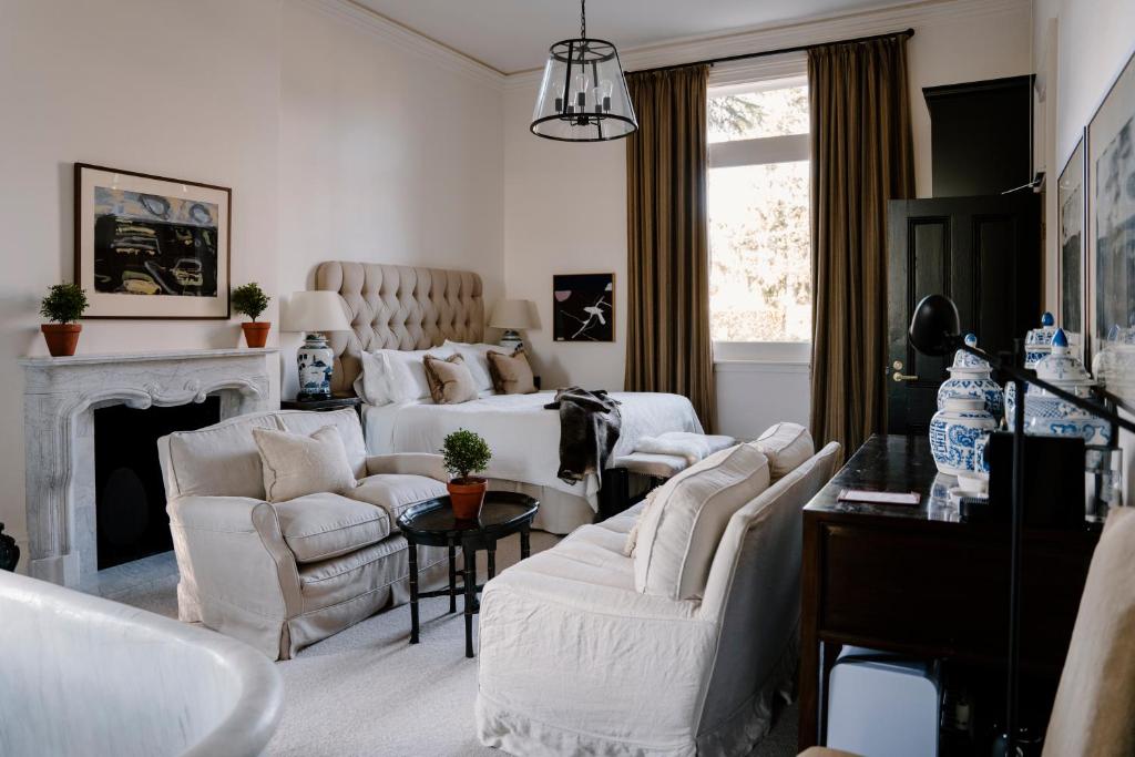 a living room with white furniture and a fireplace at Moss Manor in Moss Vale