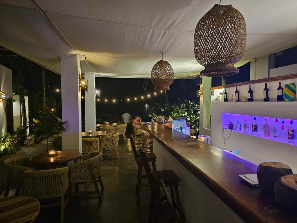 a bar in a restaurant with chairs and tables at Makao Beach Hotel in Palomino