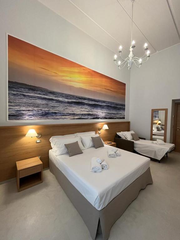 a bedroom with two beds and a painting on the wall at Il Pepe Affittacamere in Bisceglie