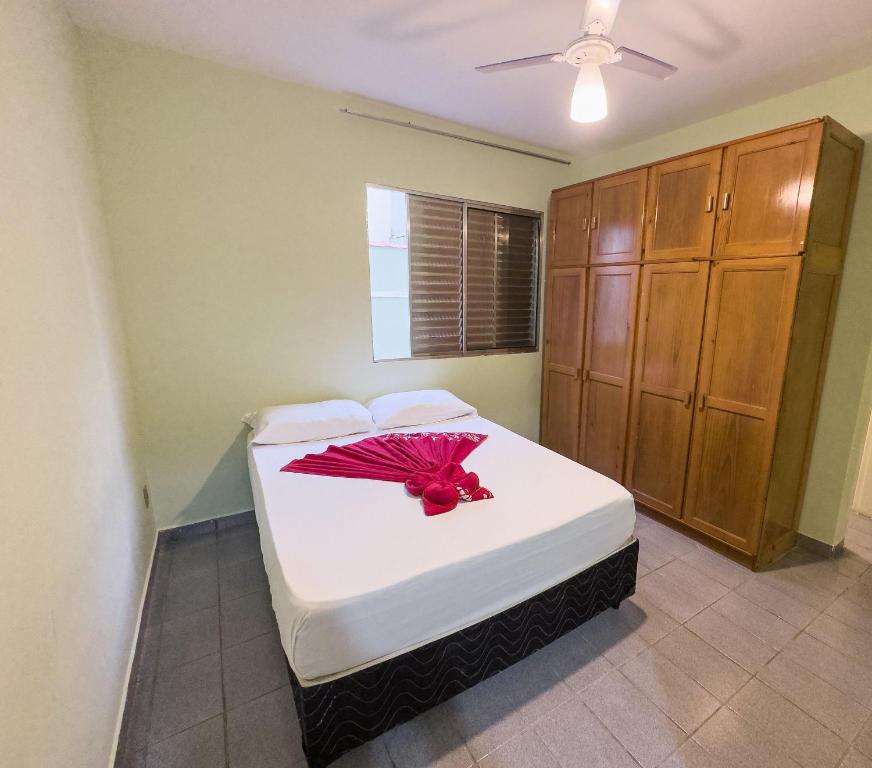 烏巴圖巴的住宿－Apartamentos Incríveis Primeira Quadra Mar WiFi，一间卧室配有一张红色遮阳伞的床