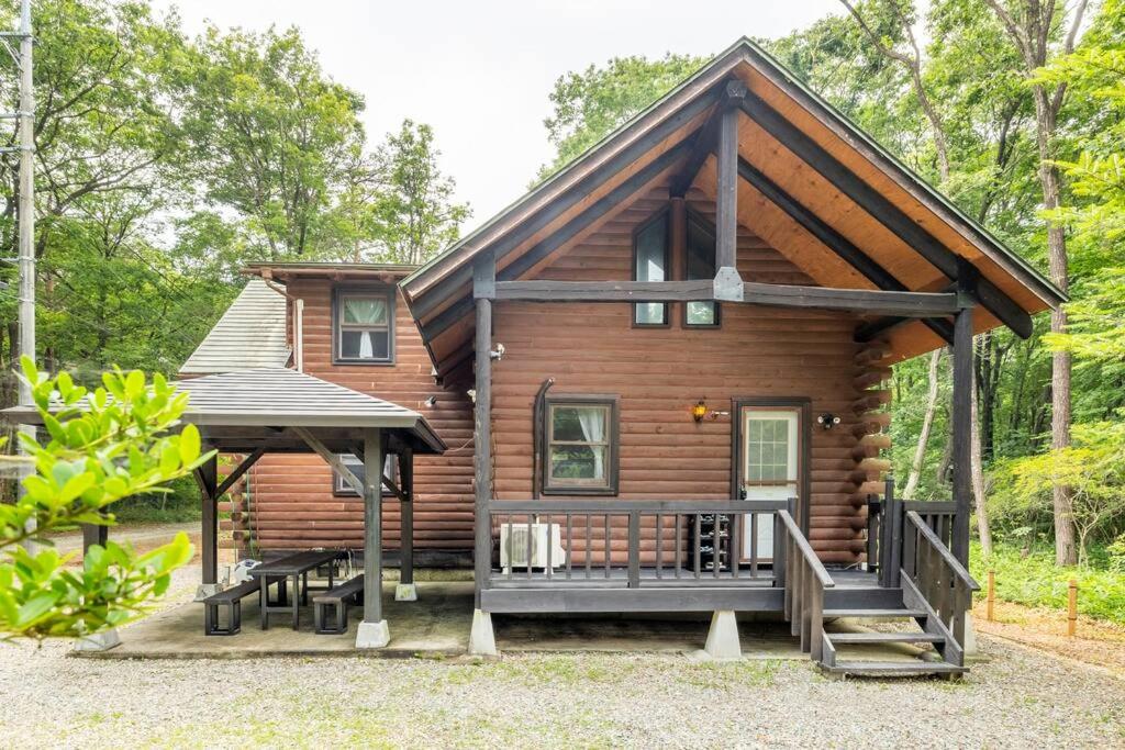 eine Blockhütte mit einer Veranda und einem Pavillon in der Unterkunft COTTAGE SaY in Nasushiobara