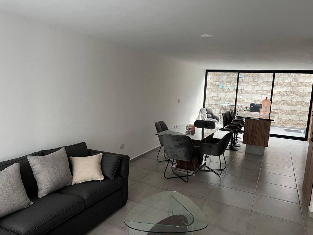 sala de estar con sofá y mesa con sillas en Residencia comoda, en Santa María Coronanco