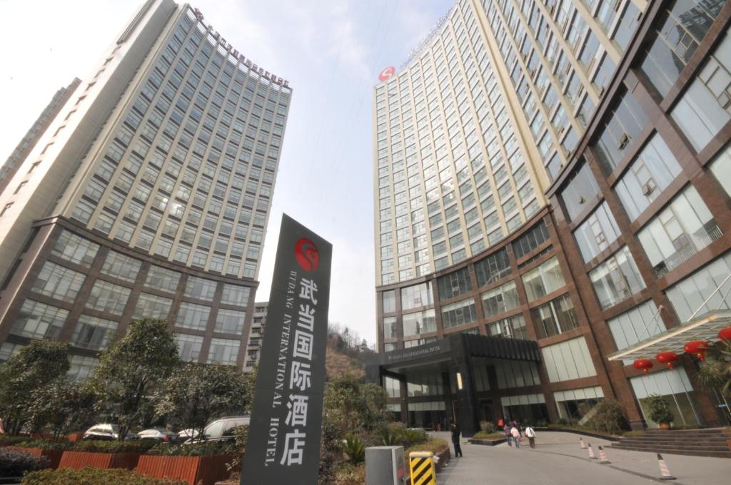un cartello di fronte a due edifici alti di Wudang International Hotel a Shiyan