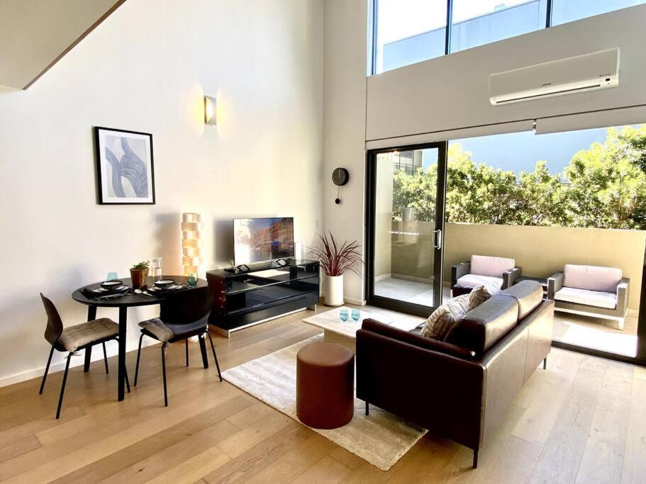 un soggiorno con divano e tavolo di Loft Style 1 bedroom Apartment a Sydney