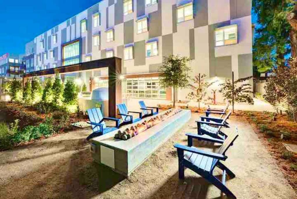 a row of blue benches in front of a building at Luxury Condo Fully Furnished Pool, Gym and Hot Tub in Mountain View