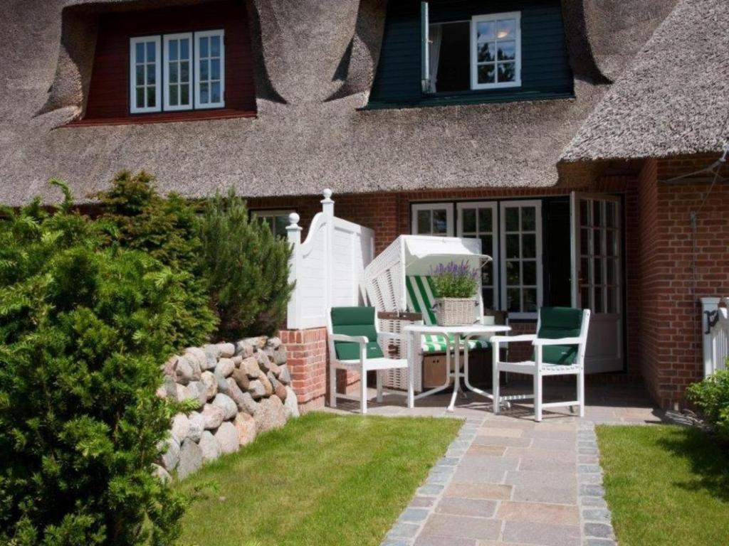 a patio with chairs and a table in front of a house at Spatzennest in Kampen