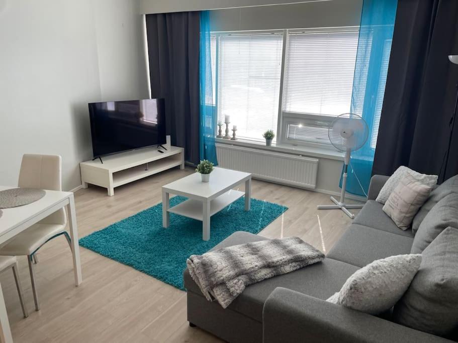a living room with a couch and a table at Utopia 1BR and sauna in Tornio