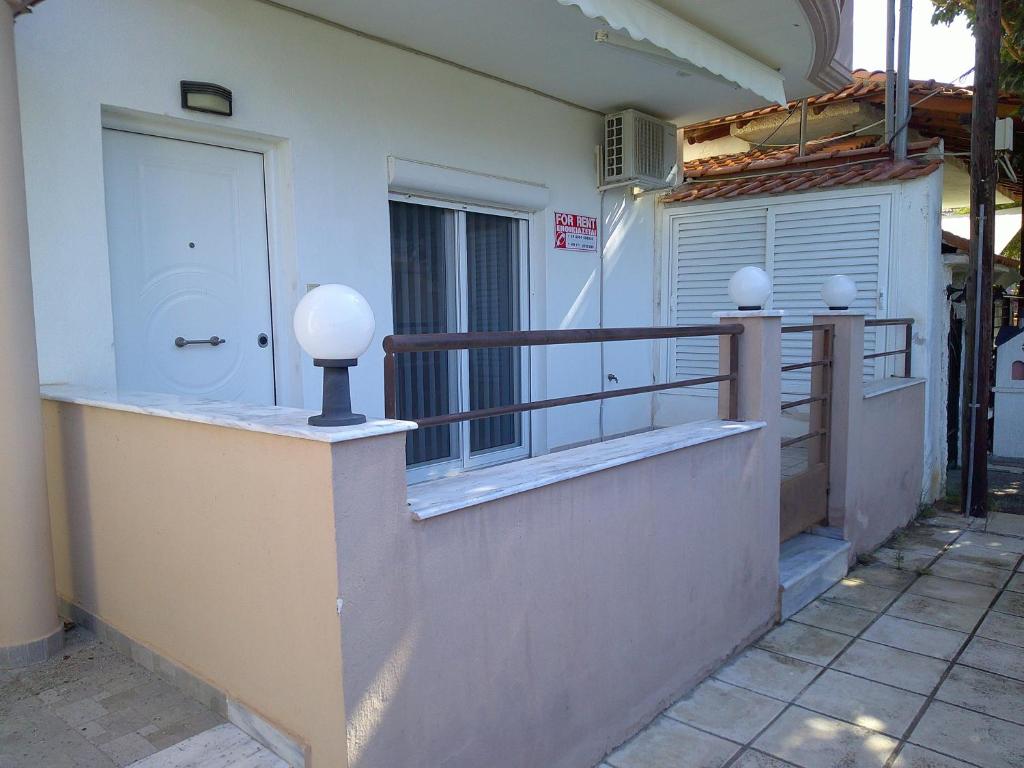 balcón de una casa con puerta y barandilla en Konstantinos Apartmend Halkidiki, en Sozopoli