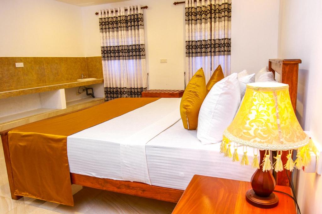 Postel nebo postele na pokoji v ubytování Hotel Nilketha Yala Tissamaharama