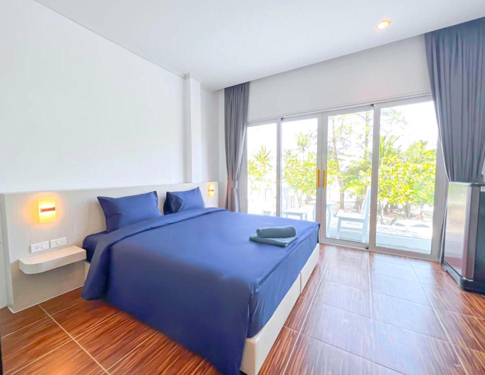 a bedroom with a blue bed and a large window at 88 House Patong in Patong Beach