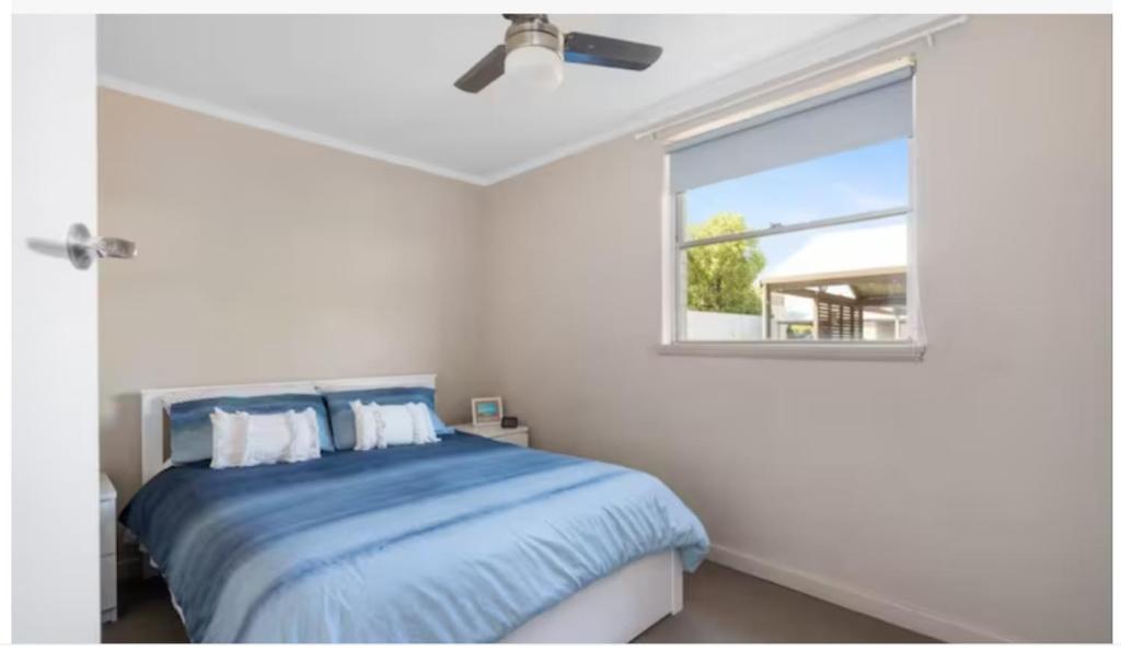 a bedroom with a blue bed with a window at Kalgoorlie Central Accommodation in Kalgoorlie