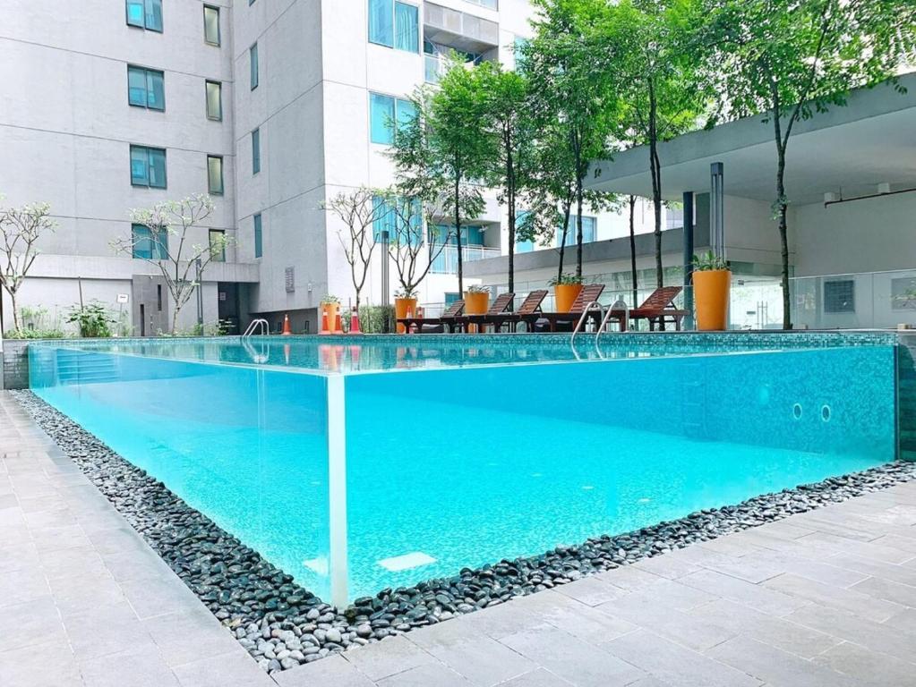 a swimming pool with blue water in front of a building at Mercu Summer Suite Kuala Lumpur in Kuala Lumpur