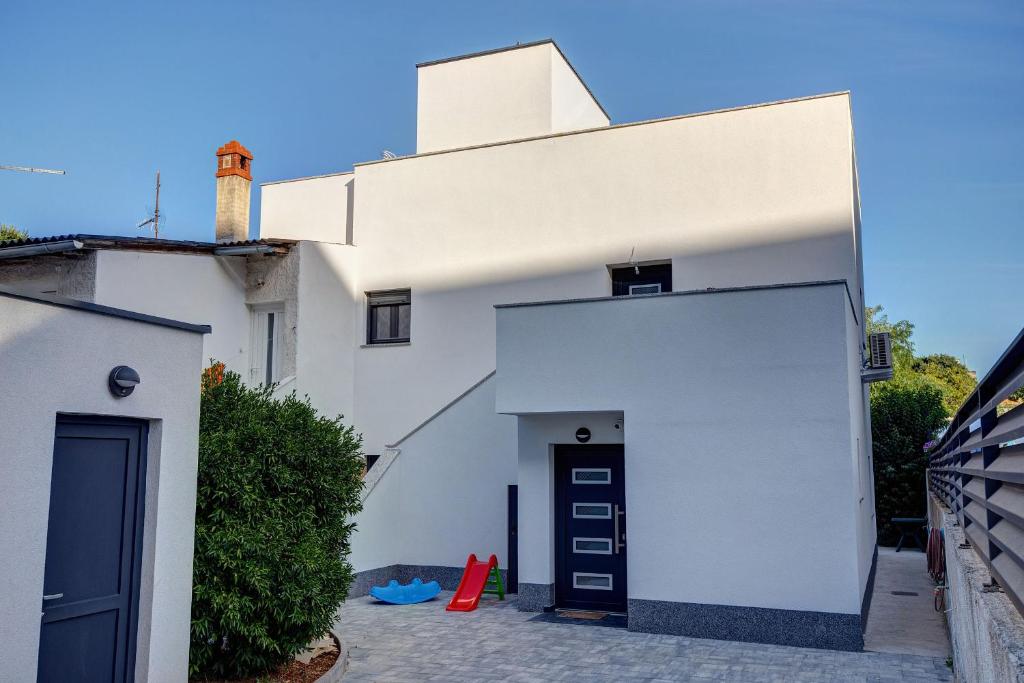 una casa blanca con una puerta delante en Villa MiEma with Jacuzzi en Zadar