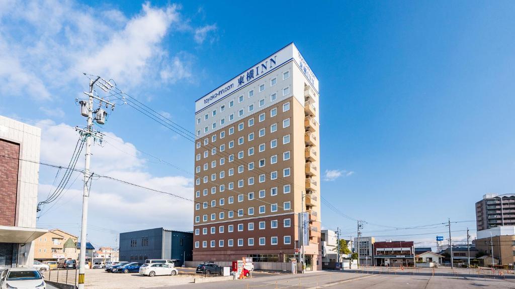 un edificio alto con un cartel encima en Toyoko Inn Meitetsu Chiryu Ekimae, en Chiryu