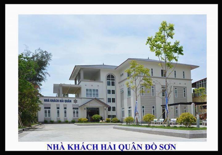 un gran edificio blanco con un cartel delante en Nha Khach Hai Quan en Ðố Sơn