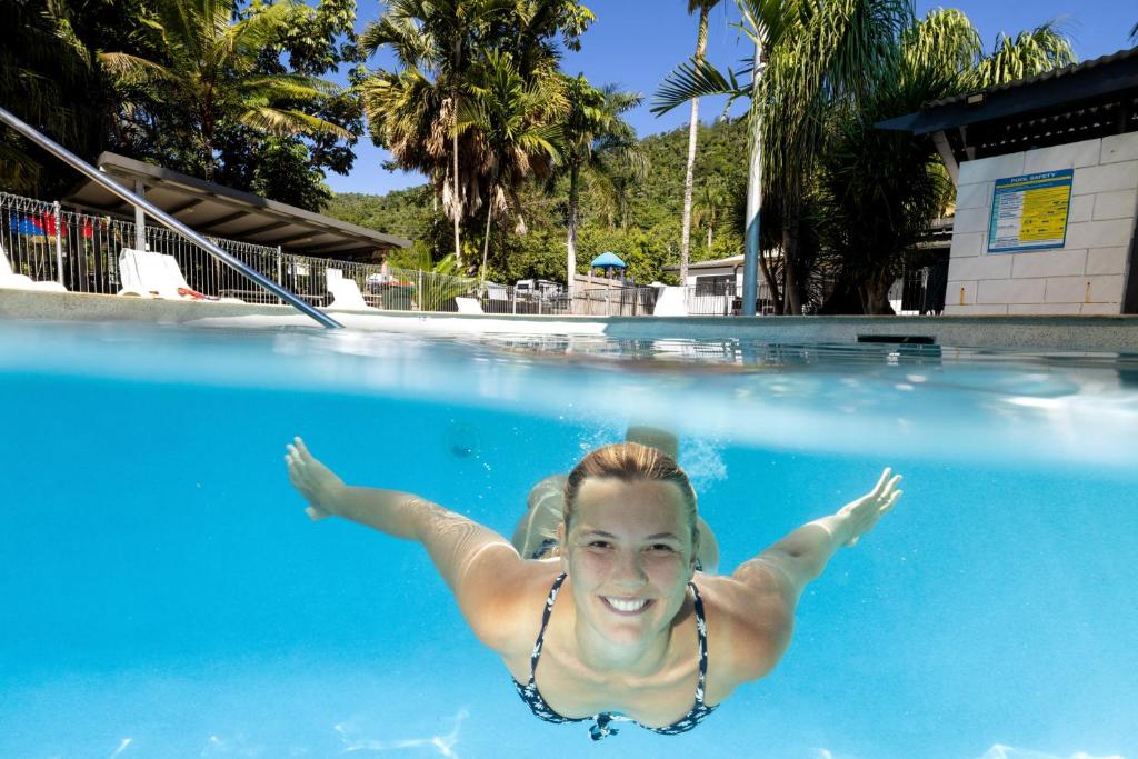 a woman swimming in a swimming pool at BIG4 Whitsundays Tropical Eco Resort in Airlie Beach