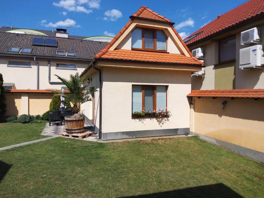 a house with an orange roof and a yard at RRR Apartmány in Bojnice