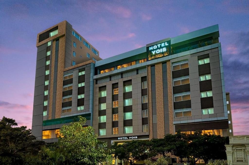 a hotel building with a sign on top of it at Hotel Yois in Udaipur