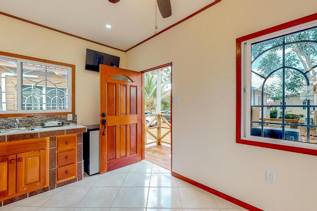 a kitchen with a door leading to a patio at Hummingbird Estate in Dangriga