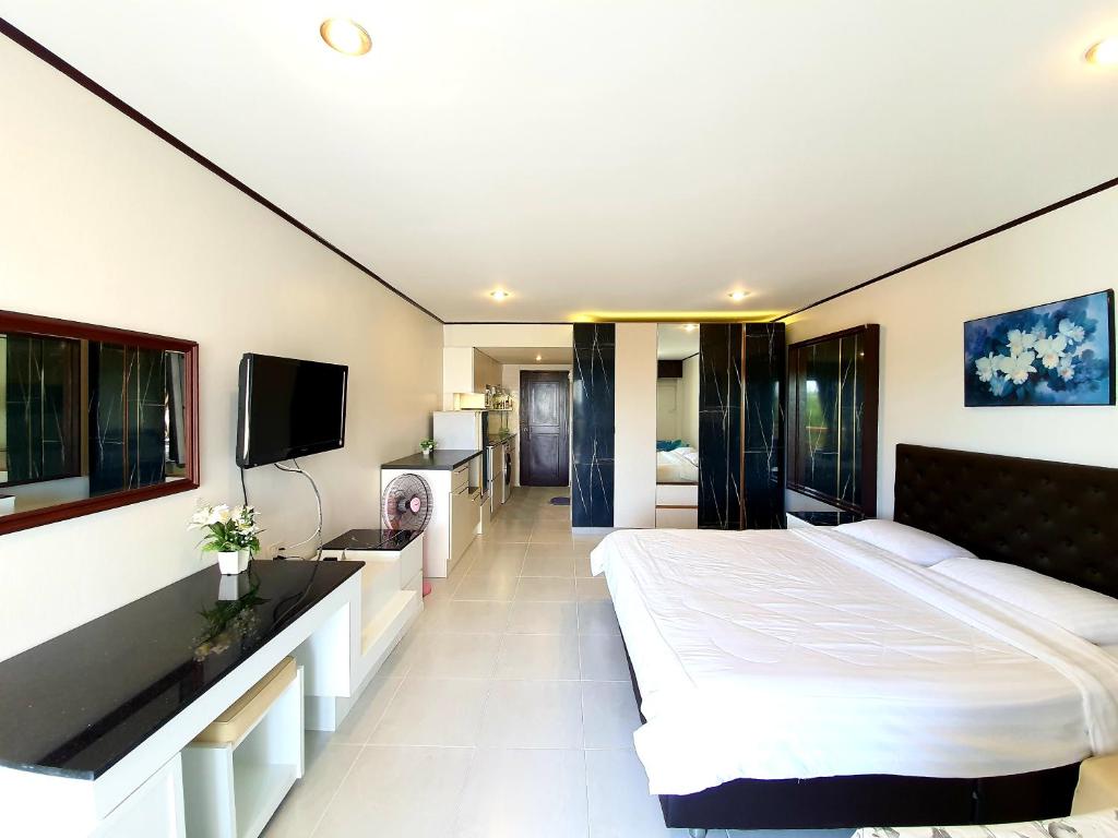 um quarto com uma cama grande e uma televisão de ecrã plano em Sea Sand Sun Resort em Rayong