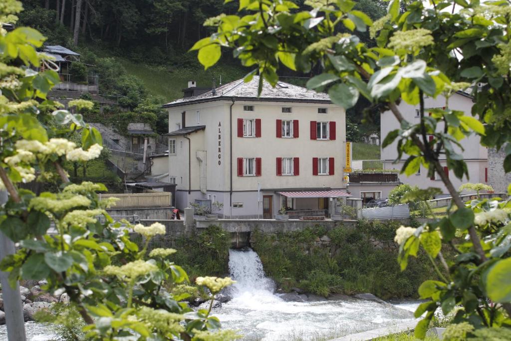 a white building with a bridge over a river at Hotel Foppoli in Poschiavo