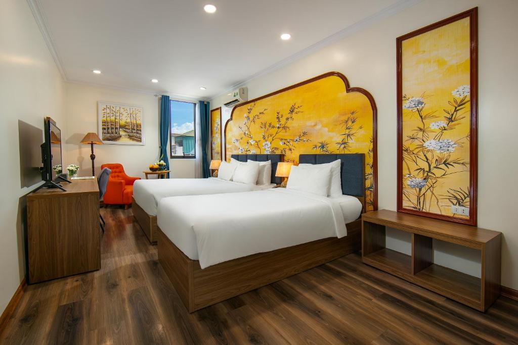 a bedroom with a large bed and a large painting on the wall at The Sono Hanoi Hotel in Hanoi