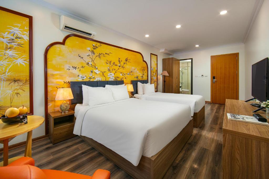 ハノイにあるThe Sono Hanoi Hotelの大きなベッドとテレビがあるホテルの部屋