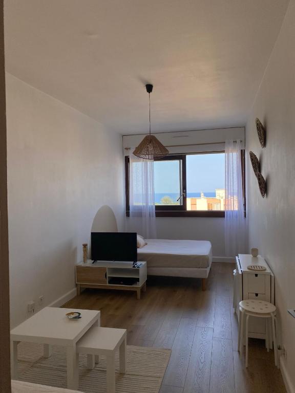 un salon avec un lit et une fenêtre dans l'établissement Studio moderne avec vue mer - Pietranera - Proche Bastia, à Pietranera
