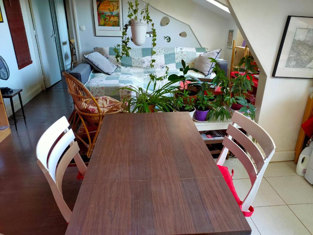 un comedor con mesa y algunas plantas en Charmant 2 pièces Clichy Levallois, en Clichy