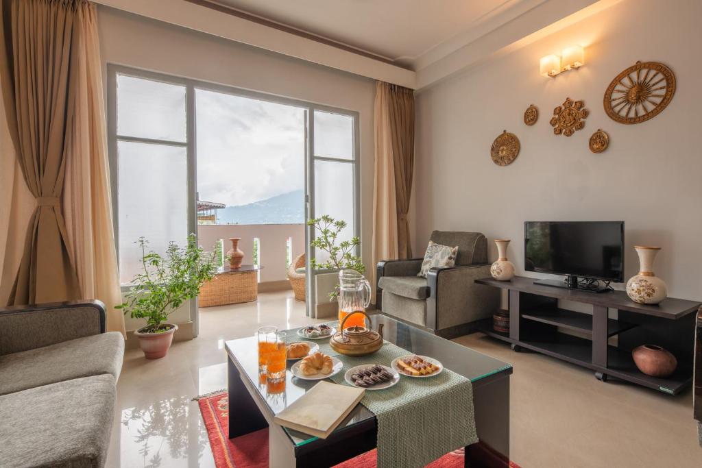 sala de estar con sofá y mesa en StayVista's Mystic Nest - Mountain & Valley-View Apartment with Contemporary Interiors & Modern Amenities, en Gangtok
