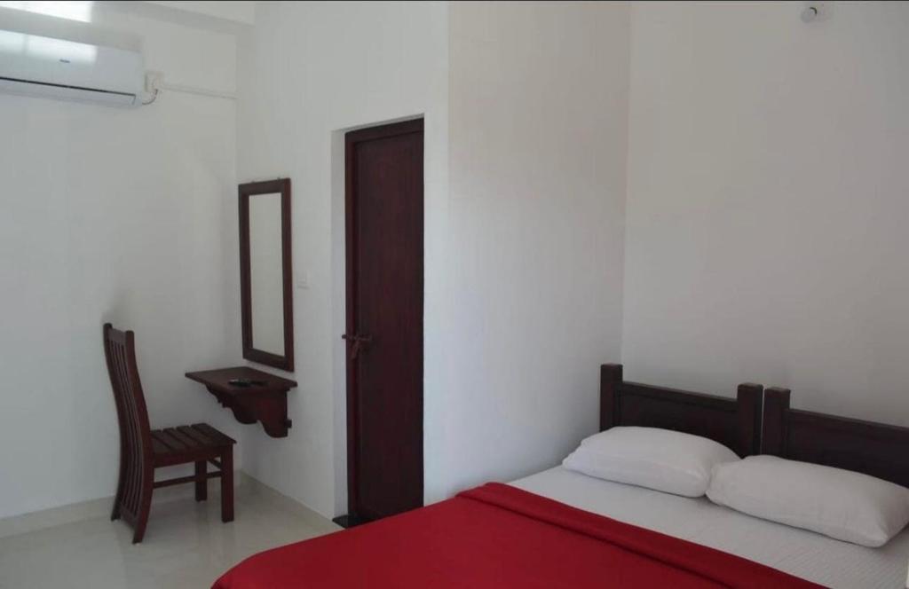 a bedroom with a bed and a chair and a mirror at OYO Flagship Sb Residency in Alleppey