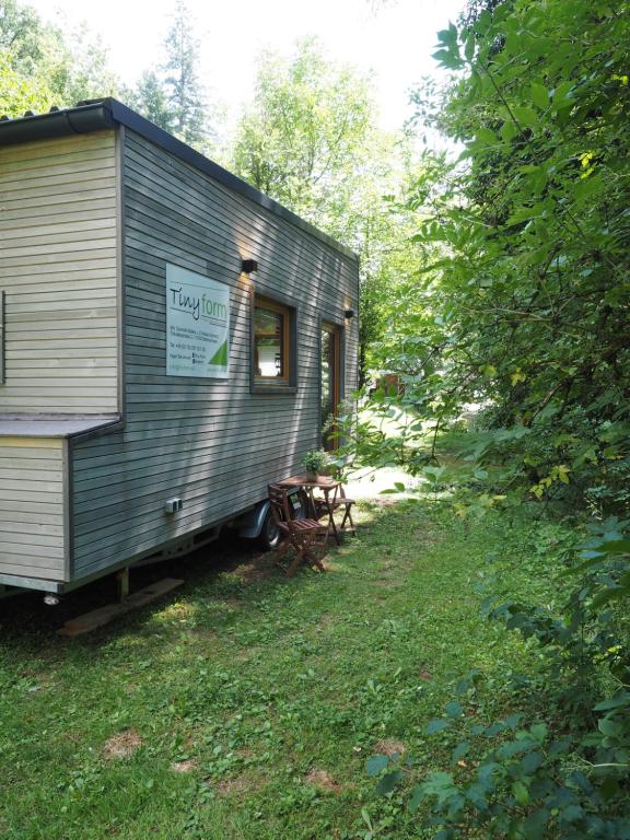 szary wagon kolejowy zaparkowany na trawie w obiekcie Tiny House am idyllischen Schlüchttal Naturcampingplatz w mieście Waldshut-Tiengen