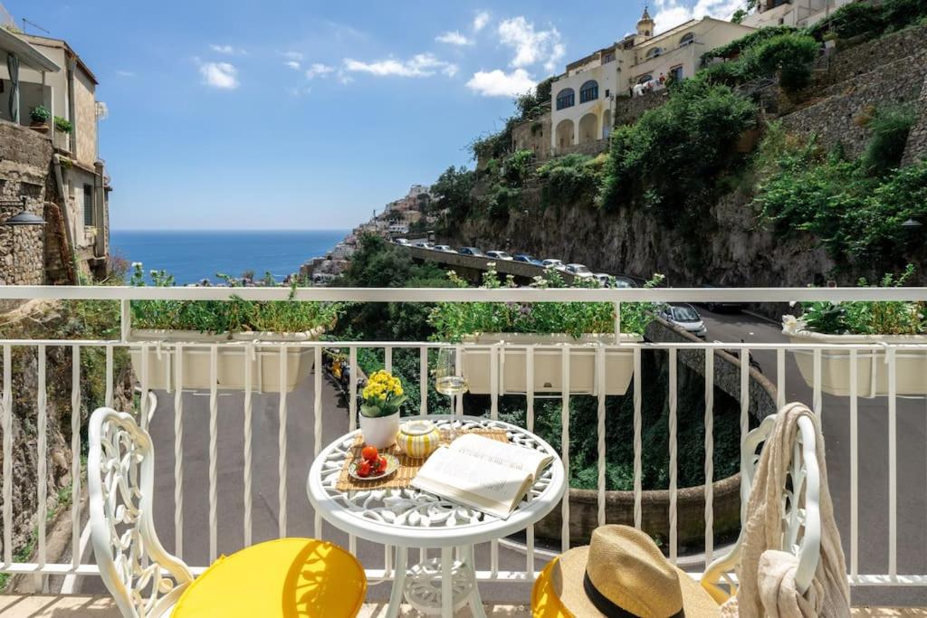 a balcony with a table and chairs and the ocean at House on the rock in Positano