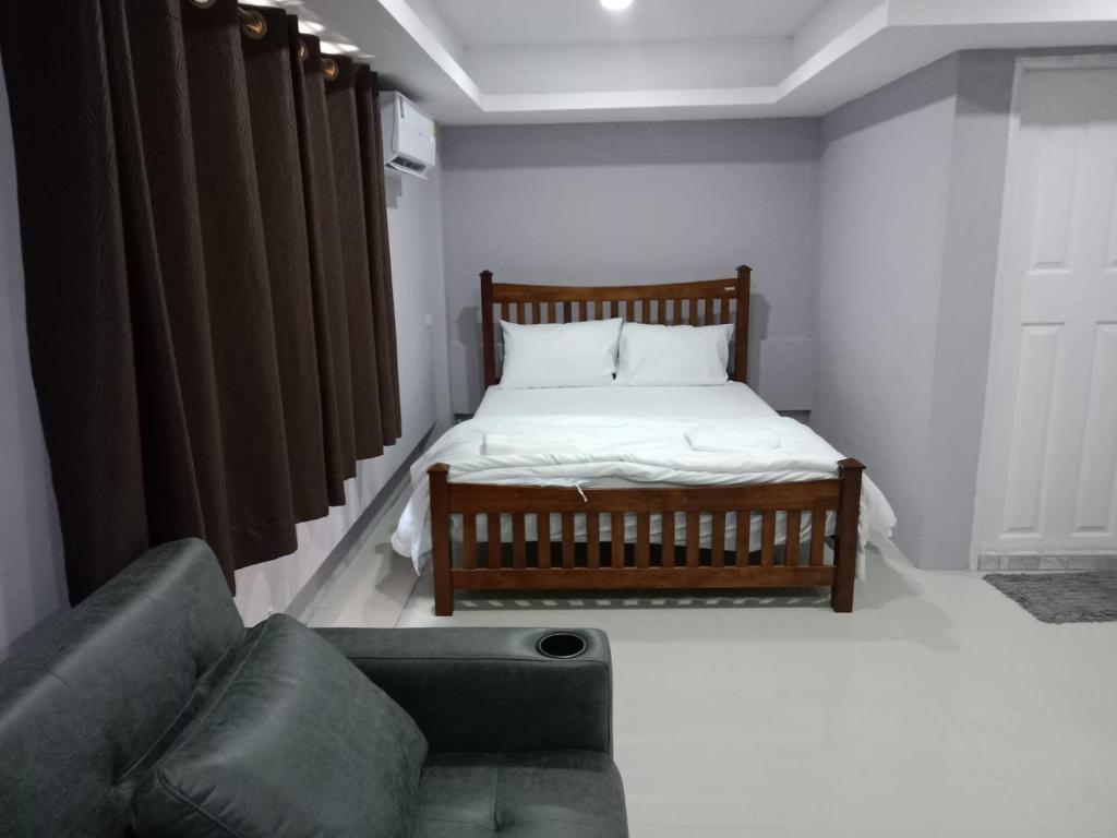 a small bedroom with a bed and a couch at Tulsi Inn at Walking Street in Pattaya South