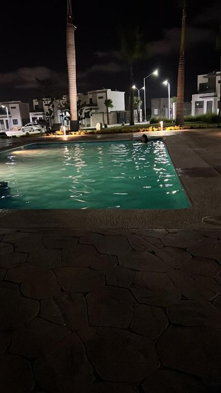 uma piscina de água verde num parque de estacionamento à noite em Casa en Mazatlán em Mazatlán