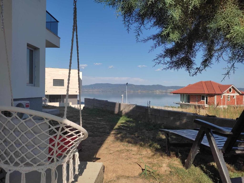 - une balançoire en face d'une maison avec vue sur l'eau dans l'établissement Villa Twins, à Nov Dojran