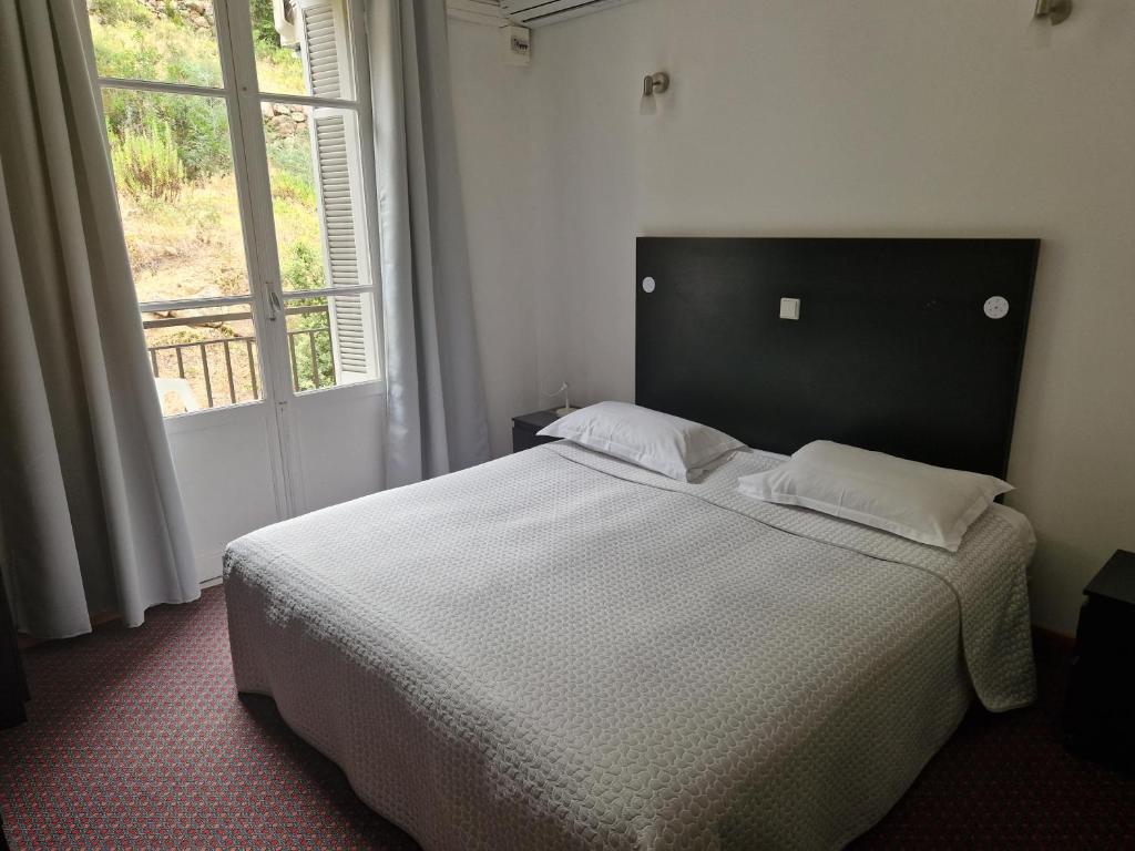 1 dormitorio con 1 cama grande y ventana grande en Le Vaita en Porto Ota