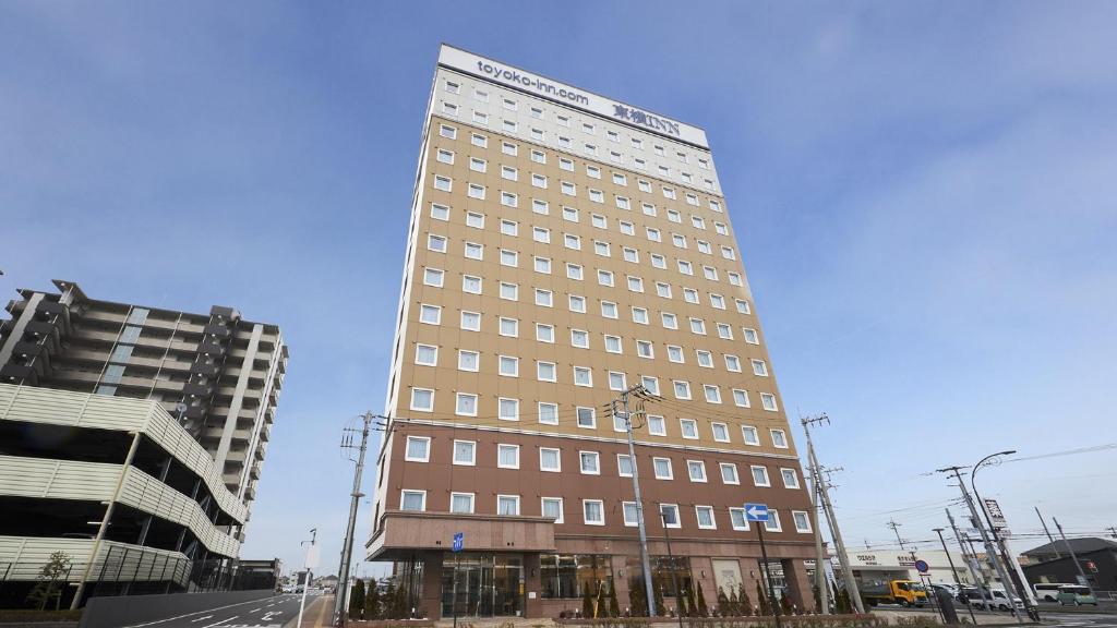 a tall building on the corner of a street at Toyoko Inn Sodegaura eki Kita guchi in Sodegaura