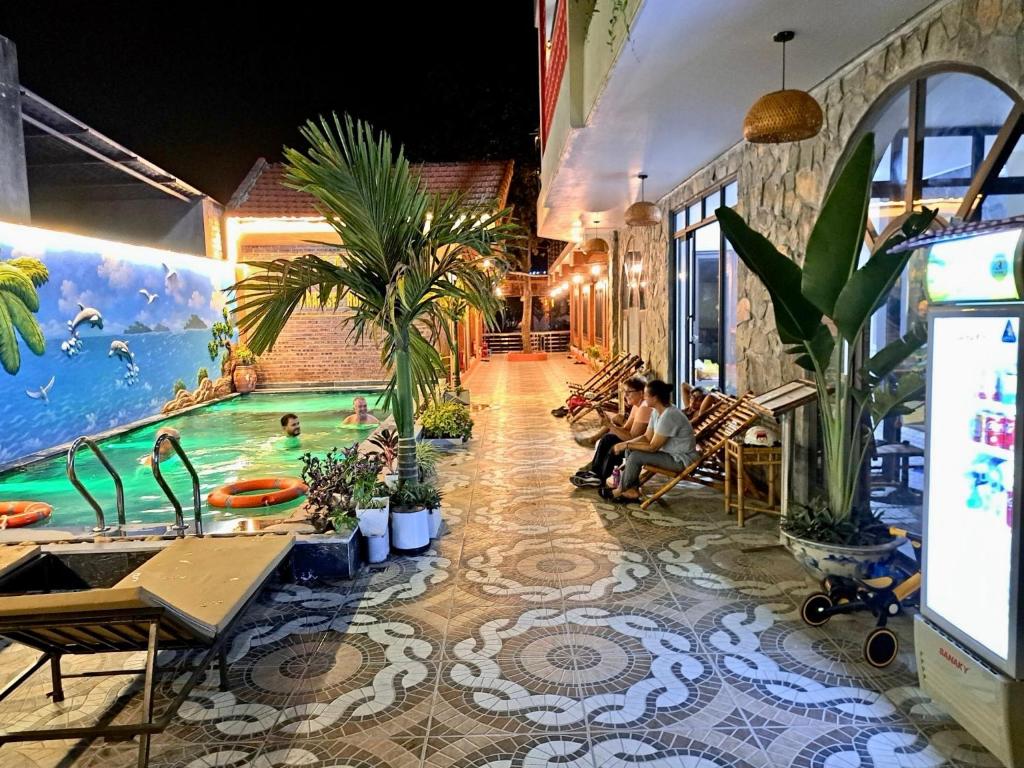 a indoor pool with people sitting in chairs in a building at Tam Coc Paradise Homestay in Ninh Binh