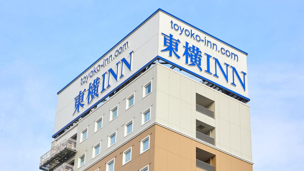 un edificio con signos azules en el costado en Toyoko Inn Omori, en Tokio
