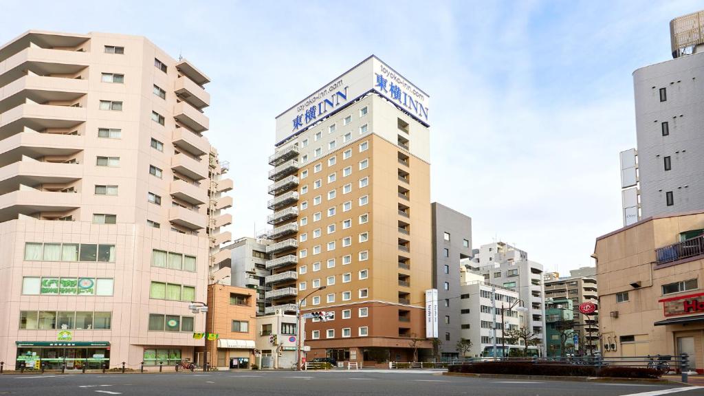 een hoog gebouw met een bord erop bij Toyoko Inn Omori in Tokyo