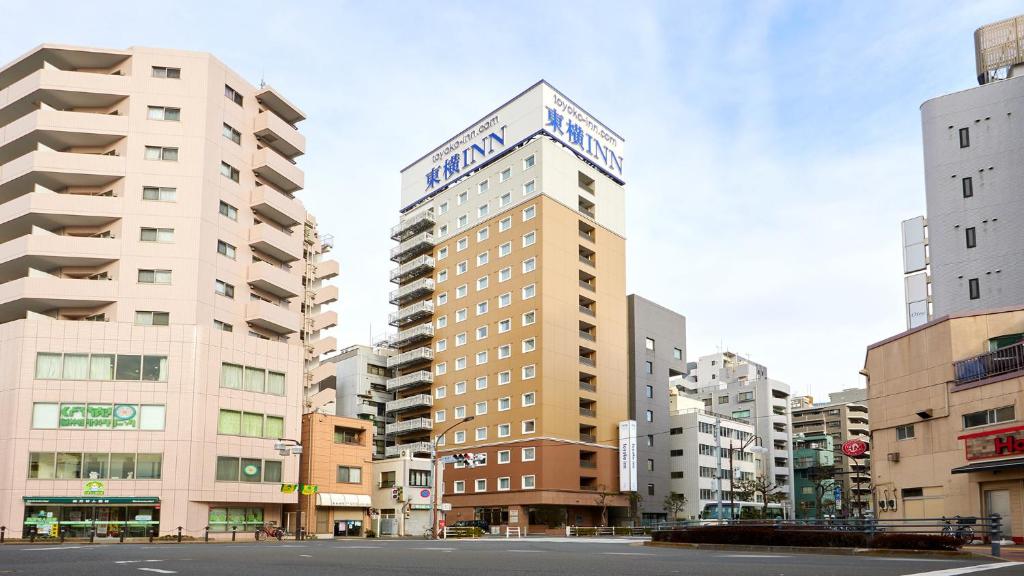 Un palazzo alto con un cartello sopra. di Toyoko Inn Omori a Tokyo