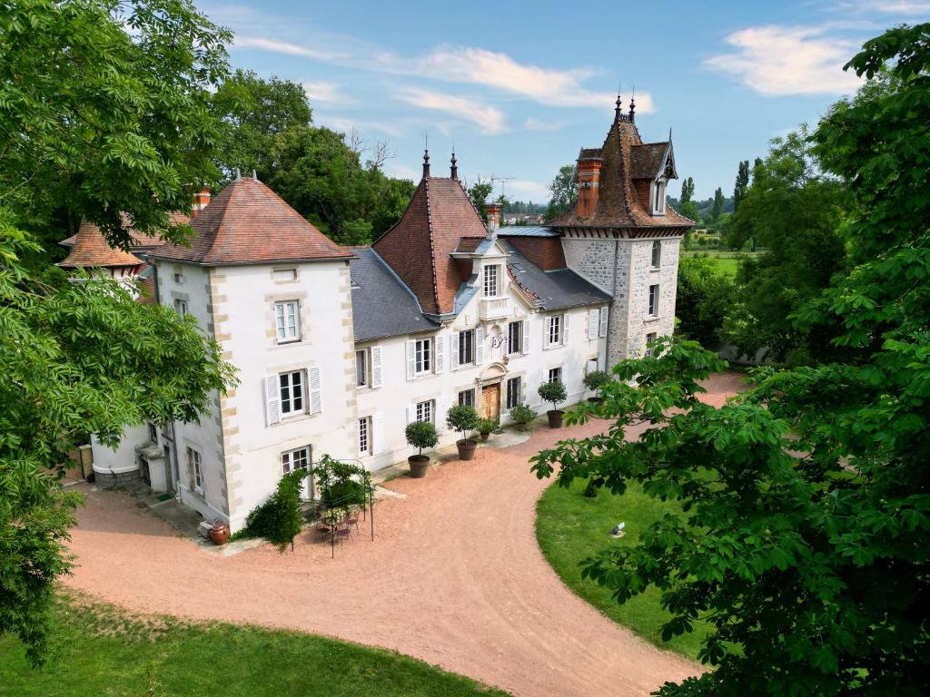 ein altes Schloss mit einer Straße, die dorthin führt in der Unterkunft Château Du Guérinet in Saint-Priest-Bramefant